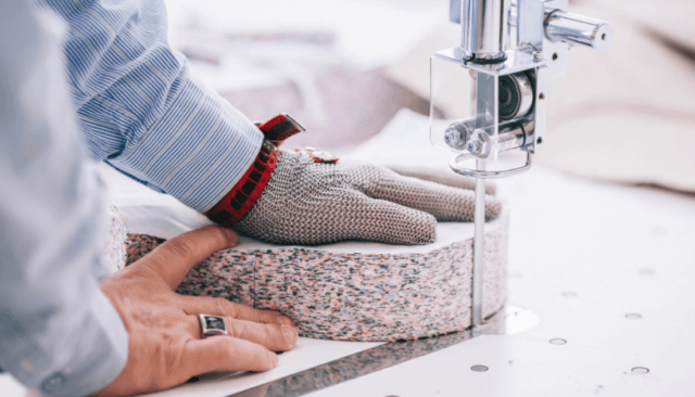 Fabric cutting machine cutting a pile of fabric