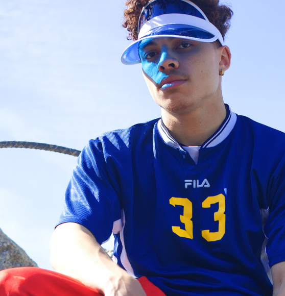 Male model wearing blue sports tshirt and blue visor looking into the camera