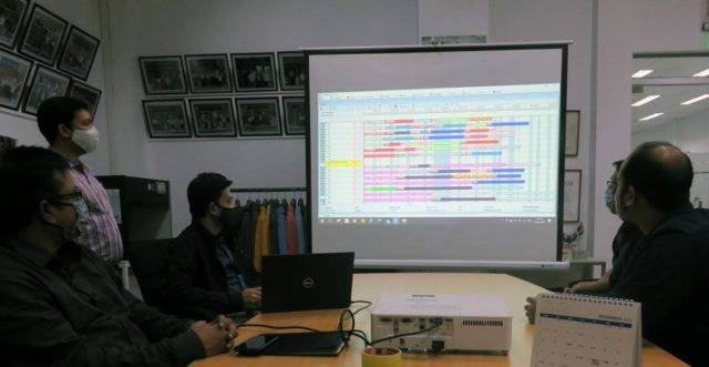 Paddock's Jeans planners wearing face masks looking at FastReactPlan on big screen