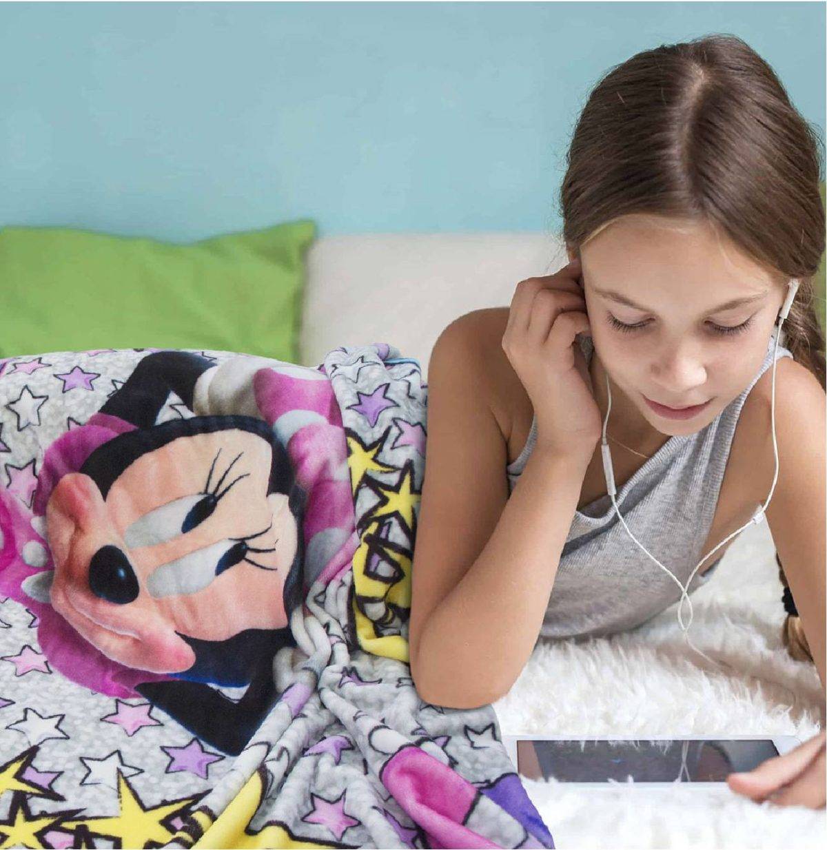 Girl with headphones under Minnie mouse duvet cover