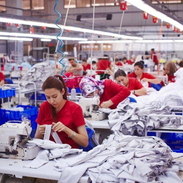 Garment factory production workers wearing red using sewing machines