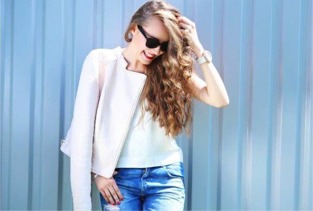 Women with curly hair modeling white clothes on blue background