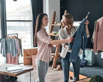 Young woman selecting clothes in fashion boutique