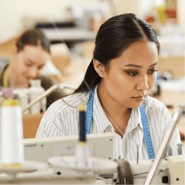 服装厂裡, 女裁缝脖子上挂着蓝色卷尺