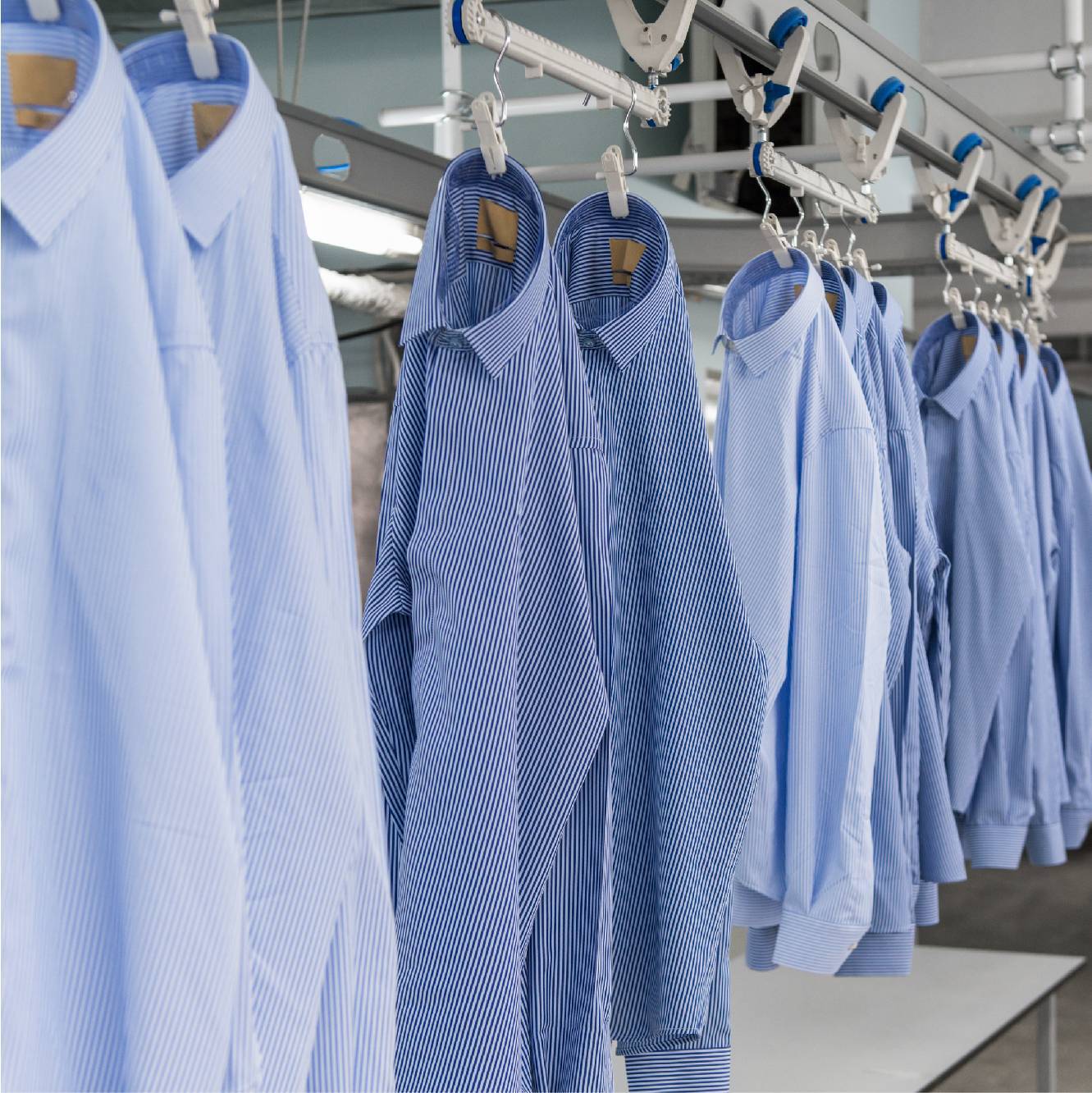 Blue striped shirts hanging in factory
